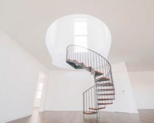 سلم حلزوني معدني أنيق في مساحة داخلية مفتوحة